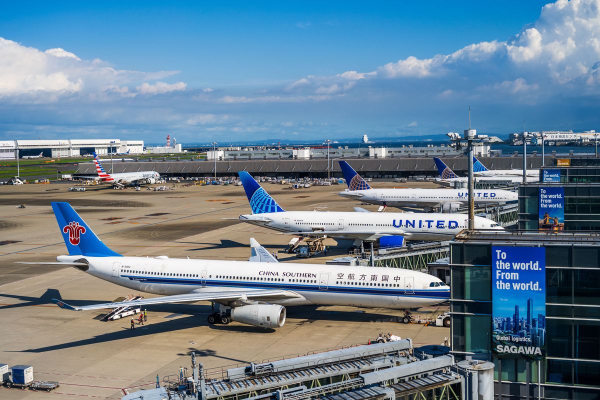 Busy runway at Narita International Airport featuring China Southern and United planes.