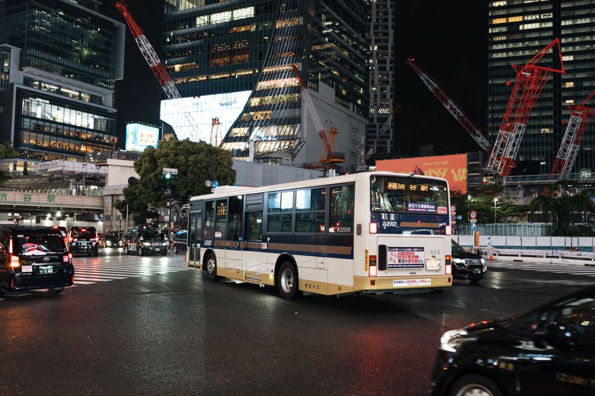 Limousine bus cruising past Tokyo evening city lights