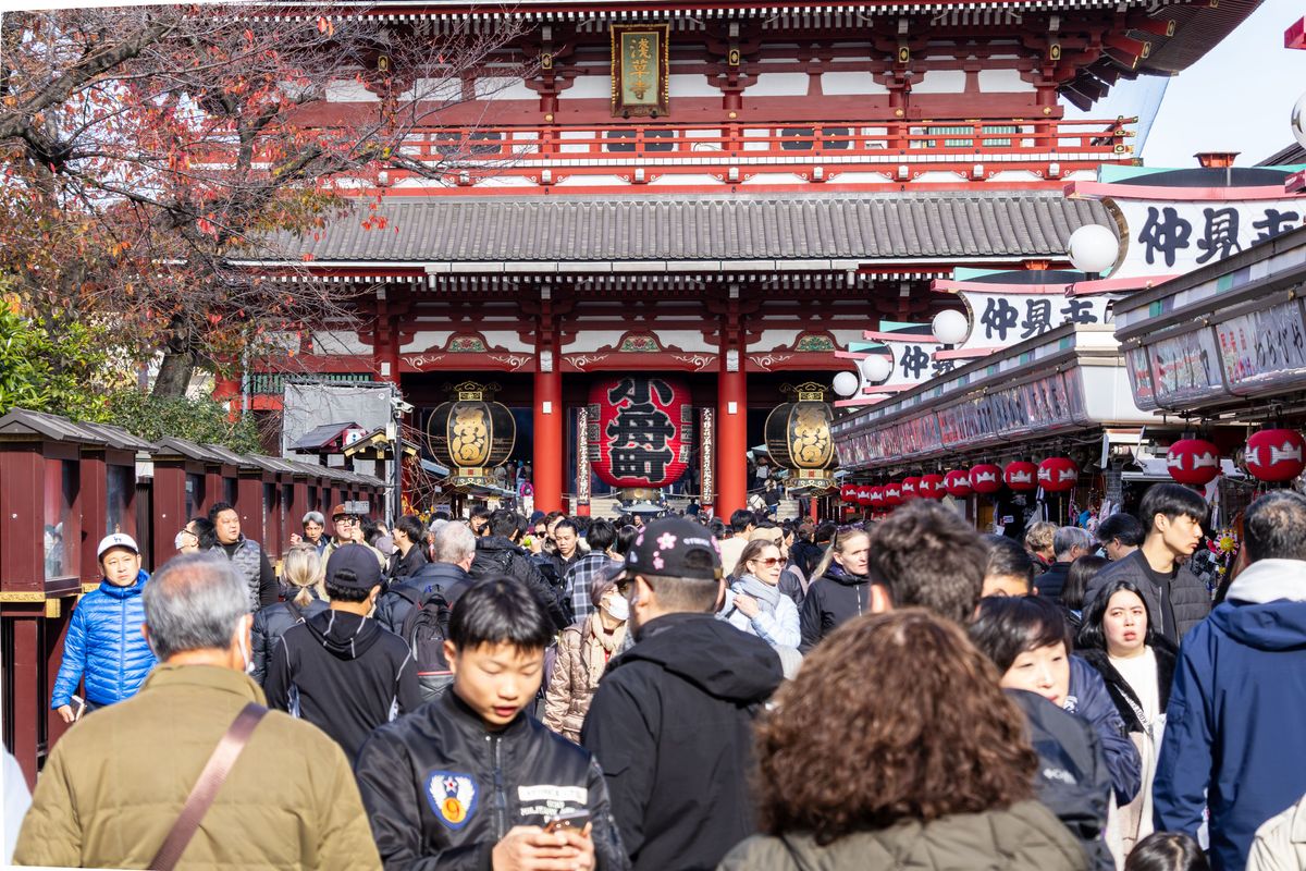 Asakusa Temple vibrant with tourists in Taito City, Tokyo on a sunny day.