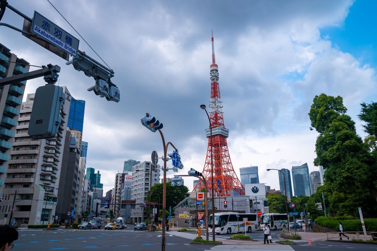 Vibrant cityscape featuring Tokyo Tower and Akabanebashi Bridge in Minato, Tokyo. Bright day with bustling urban life.